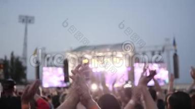 摇滚音乐会，歌迷在音乐会上鼓掌，许多人拍手，观众在户外