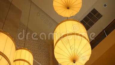 吊在天花板上的纸灯笼.. 悬挂在天花板上的中国纸灯笼。 黄色的中国纸灯笼