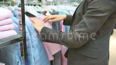 妇女在服装店购物时选择物品