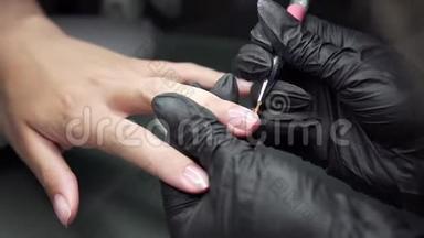 美甲师在美甲沙龙里对女孩的指甲进行修脚和延长指甲的程序