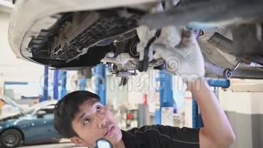 亚洲机械保持和闪光手电筒检查汽车盘制动垫磨损的汽车车辆。 安全悬挂
