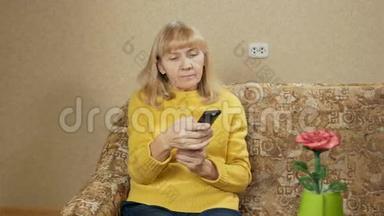 老年妇女在家里的沙发上切换遥控<strong>电视频道</strong>。 经过一天的艰苦，她正在休息。 假期概念