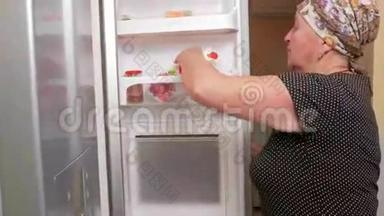 老妇人打开冰箱，喝包裹里的果汁。 它解渴，把果汁放回冰箱