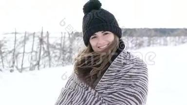 在寒冷的风天，美丽的女孩对着镜头微笑的肖像。 慢慢地