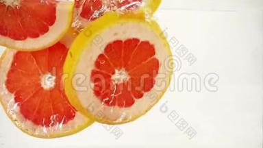 柚子橙片落入水中，溅起水花和气泡，慢动作特写
