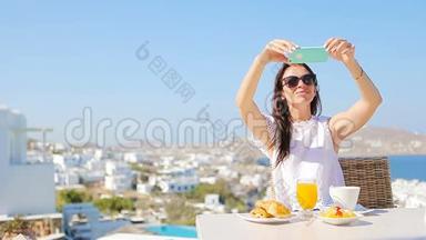 女士用手机拍照早餐。 女孩在豪华旅行度假时拍照留念