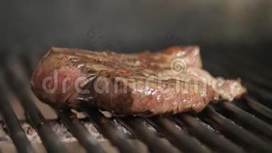 在烧烤上煎牛排。 典型的阿根廷烧烤或阿萨多。 烧烤架里的木头和红色的热煤。