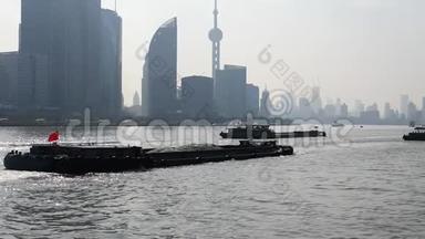 上海外滩从渡船、摩天大楼和蓝天背景的地标上观看，货船在黄浦江上航行