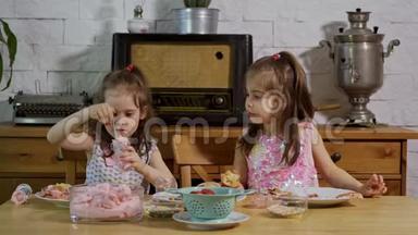 两个小女孩穿上<strong>奶油</strong>，在木桌上装饰<strong>美味</strong>的纸杯<strong>蛋糕</strong>