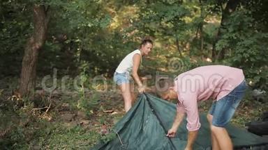 年轻夫妇在树林里<strong>搭帐篷</strong>