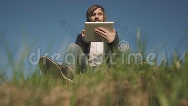 坐在草地上用平板电脑看帅哥的<strong>底图</strong>