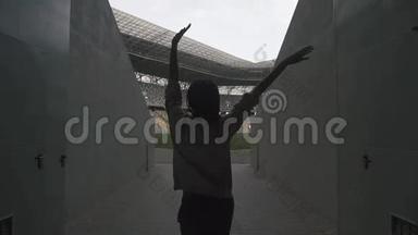体育场上非洲妇女的剪影，举手<strong>致胜</strong>。双赢理念