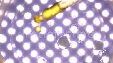油滴在多个点灯紫色背景下<strong>落入</strong>水中。 科学实验概念。 4K视频