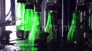 线的制水.. 绿色玻璃瓶沿着生产线自动移动，并装满水