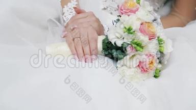 精致的新娘捧着美妙的花束。 金色戒指。 结婚庆典。 传统。 新娘饰物，粉红色