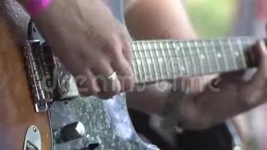 这位音乐家在<strong>摇滚音乐节</strong>上演奏一把老式电吉他。 双手特写