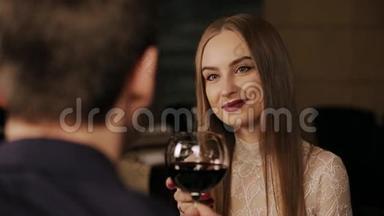年轻的情侣在浪漫的约会中喝一杯红酒
