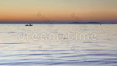 夕阳西下，渔人的船浮在平静的水面上。 4k