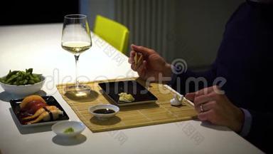 有胡子的人在晚餐时吃寿司，喝白葡萄酒