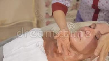 中年妇女在spa沙龙接受面颈部淋巴引流按摩
