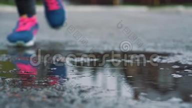 用运动鞋将跑步者腿部的慢动作镜头闭合. 女运动员在公园户外慢跑，踏入