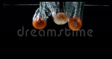 克莱门汀，柑橘，黑背景下落入水中的水果，