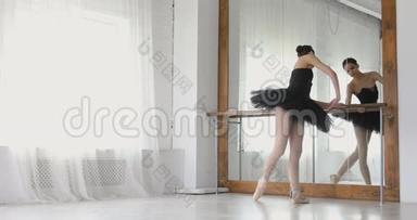 芭蕾舞女演员在酒吧里伸展，优雅的女孩在工作室里练习芭蕾