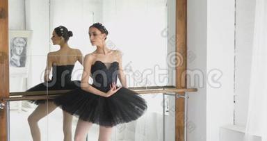 芭蕾舞女演员在酒吧里伸展，优雅的女孩在工作室里练习芭蕾