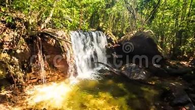 热带森林中的小瀑布落入透明池塘
