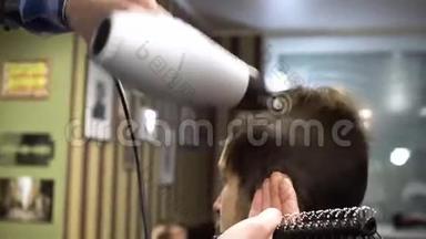 理发师在理发店用吹风机把顾客`头发烘干
