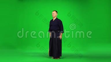 阳刚剑道战士用绿色屏幕上的竹子练习武术。