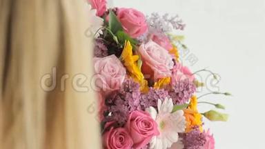 花匠把一朵玫瑰放在一大束五颜六色的花束里