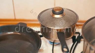 盖子远离蒸汽的压力，在锅的食物在炉子的家庭厨房。 慢动作