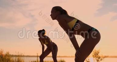 在一个美丽的夏日傍晚，运动女孩在沙滩<strong>排球比赛</strong>中跳到空中，在网上击球