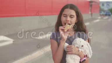 吃<strong>冰淇淋</strong>的小女孩走在街上，有一个柔软的玩具动作慢动作视频。 女孩和<strong>冰淇淋</strong>吃