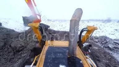 <strong>冬季雪天</strong>推土机和挖掘机配合地面工作. 从客舱看