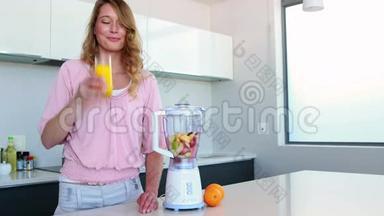厨房里的美女在<strong>榨汁</strong>机旁边喝橙汁