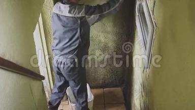 这个人用刷子和抹布擦干净<strong>墙壁</strong>上的坚固污垢。 工人手工清洗走廊<strong>墙壁</strong>.. 模具和