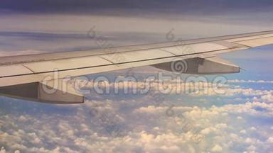 从窗口在空运机翼下观看白云