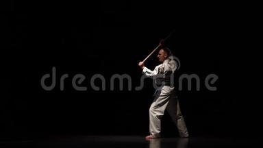 剑道战士在白色和服上练习武术，与竹子在黑色背景上。