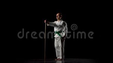 <strong>剑道</strong>战士在白色和服上练习武术，与竹子在黑色背景上。