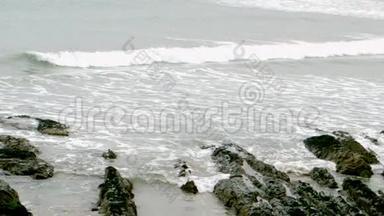 海浪在沙滩上滚过岩石
