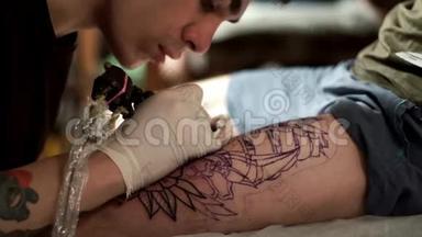 纹身师用纹身机给客户纹身