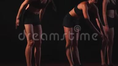 三个穿黑色衣服的女孩在<strong>比赛</strong>开始的垫子上开始<strong>比赛</strong>。