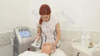 美丽的美容师为躺在美容院的女人做射频提升手术的画面