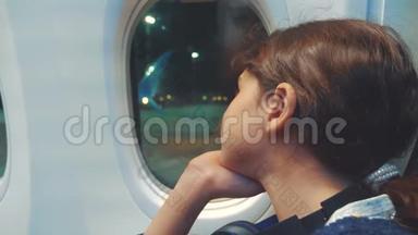 少女航空飞机概念。 年轻女孩看着坐在窗边的飞机。 晚上乘飞机飞行