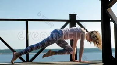 年轻女子夏天在户外练习瑜伽。 健康生活方式