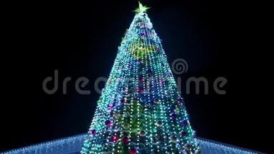 在大雪纷飞的冬夜，大圣诞树上装饰着发光的花环。 相机<strong>飞来</strong>飞去
