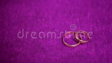 两个漂亮的结婚戒指在<strong>深</strong>紫色的背景上