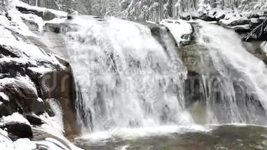 冬季瀑布。 小池塘和白雪皑皑的巨石，瀑布层层叠叠。 山河的水晶冻水和声音。